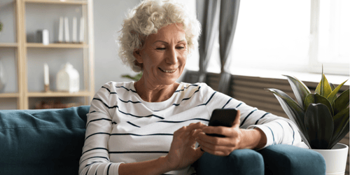 Image of elderly woman looking at her phone, potentially at a monthly donor email