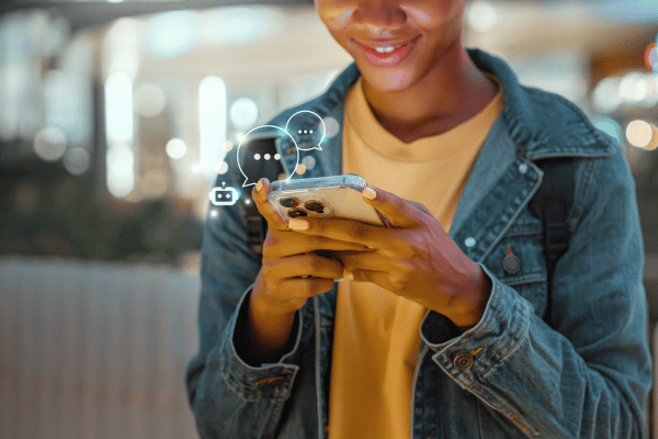 Young person looking at their phone while having a conversation with an AI agent
