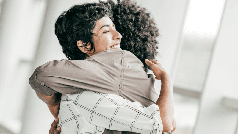 Image of two people hugging for case study: Guiding Light cuts costs by telling their own story