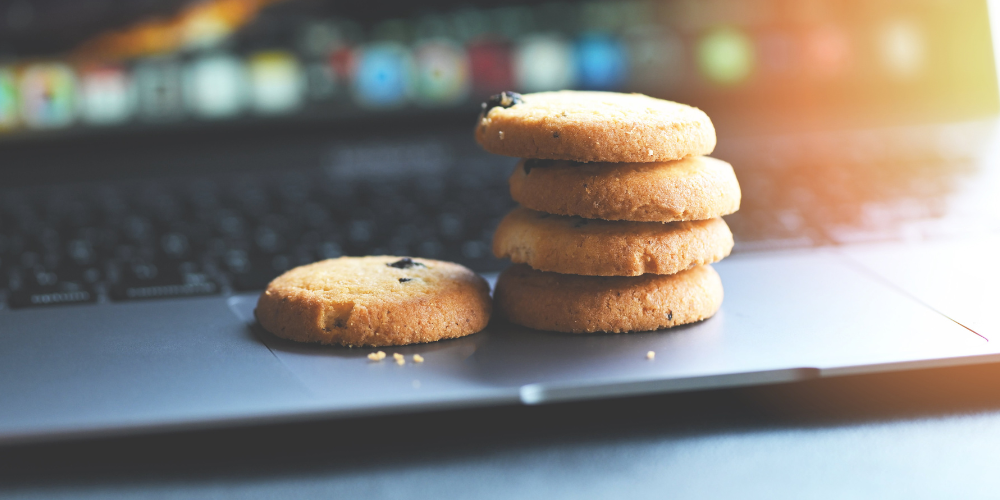 stack of cookies on laptop with blurry screen in background