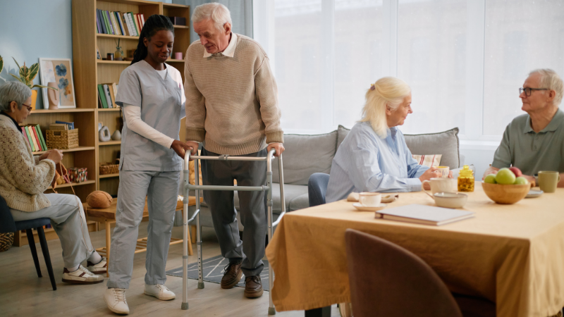 woman helping wan with walker in assisted living facility