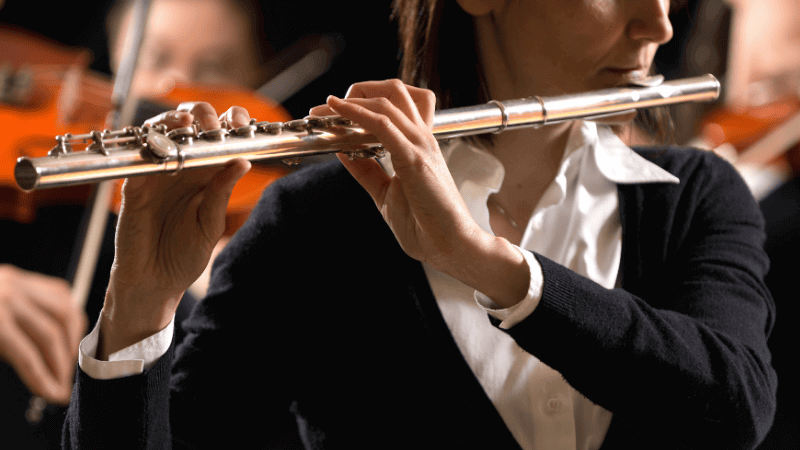 Woman playing a flute at an orchestra