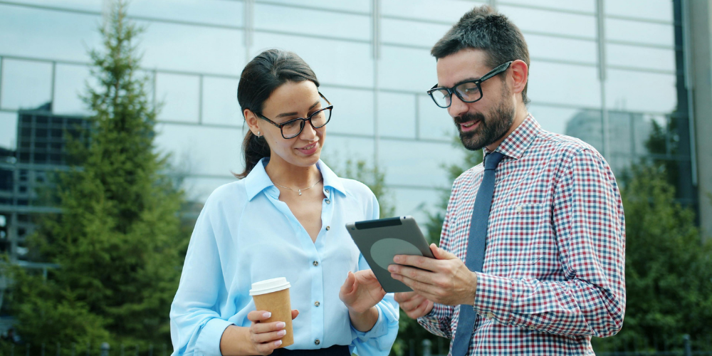 two professionals chatting and looking at a screen