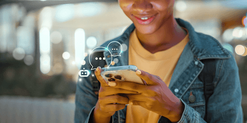 Young person looking at their phone while having a conversation with an AI agent