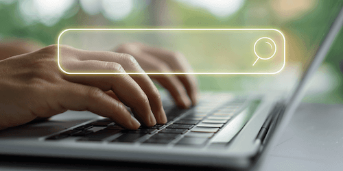 image of hands typing on laptop with a search bar superimposed for blog about how to boost your nonprofit's reach with search-based targeting